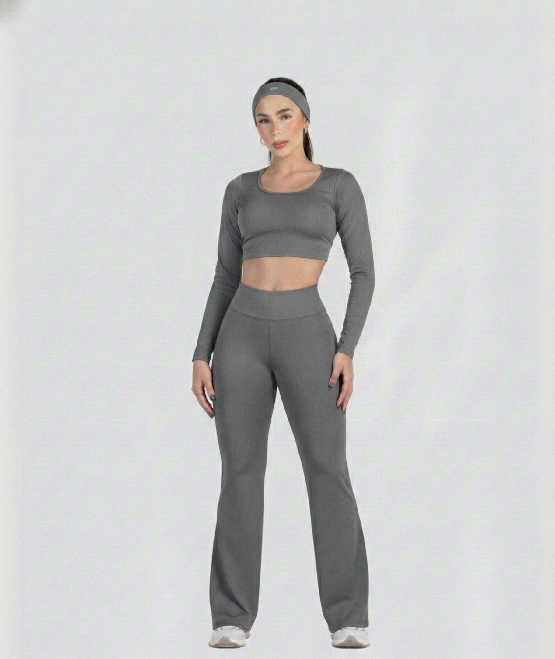 Woman wearing a gray athletic outfit CORDESET on a white background