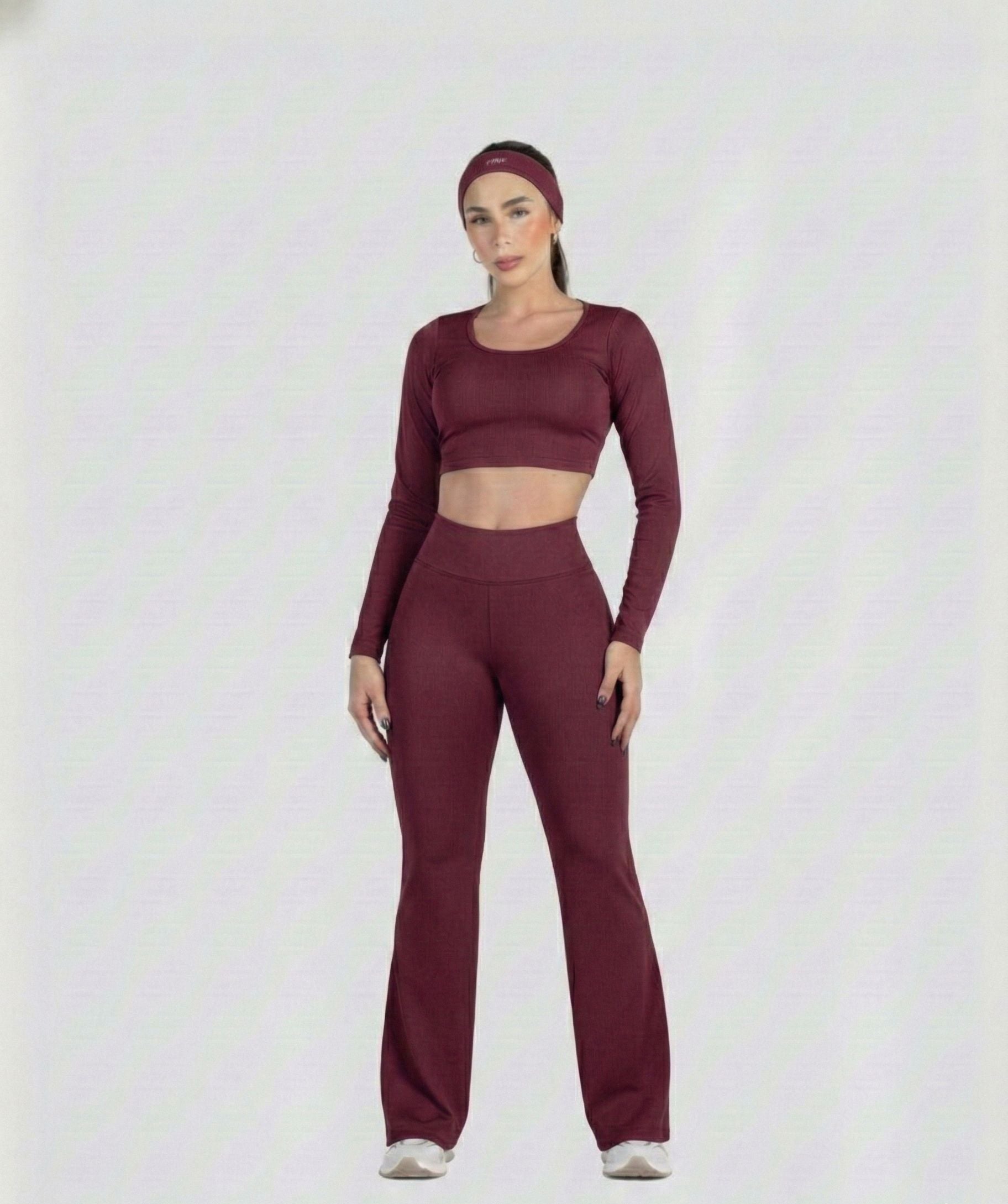 Woman wearing a maroon athletic outfit on a white background