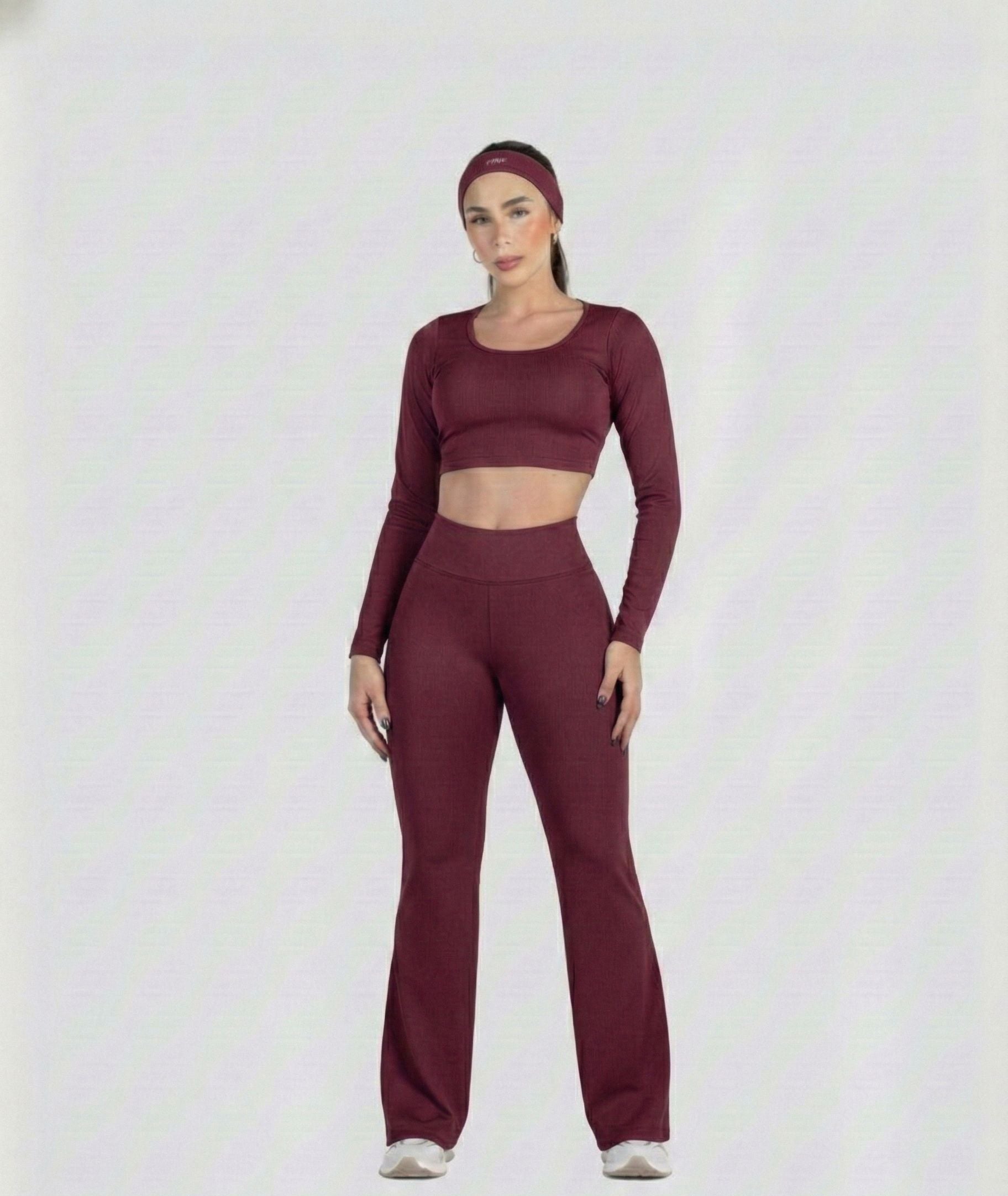 Woman wearing a maroon athletic outfit on a white background