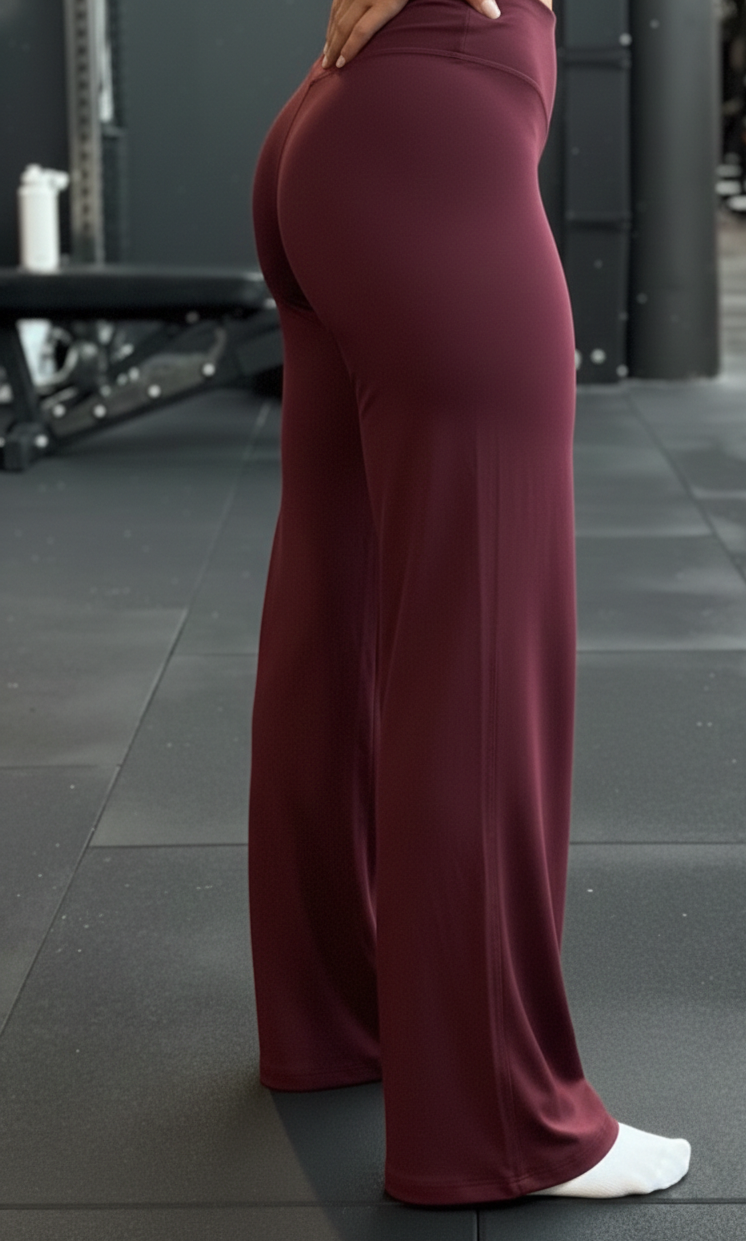 Person wearing maroon wide-leg pants in a gym setting
